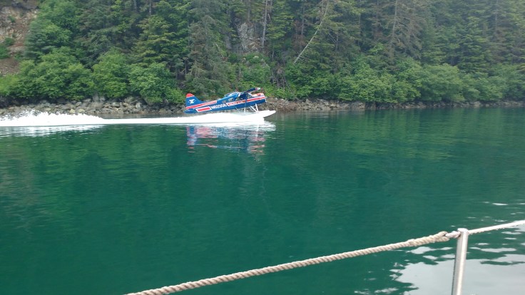 Seaplane landing next to boat entering Elfin Cove .Photo Ray Penson