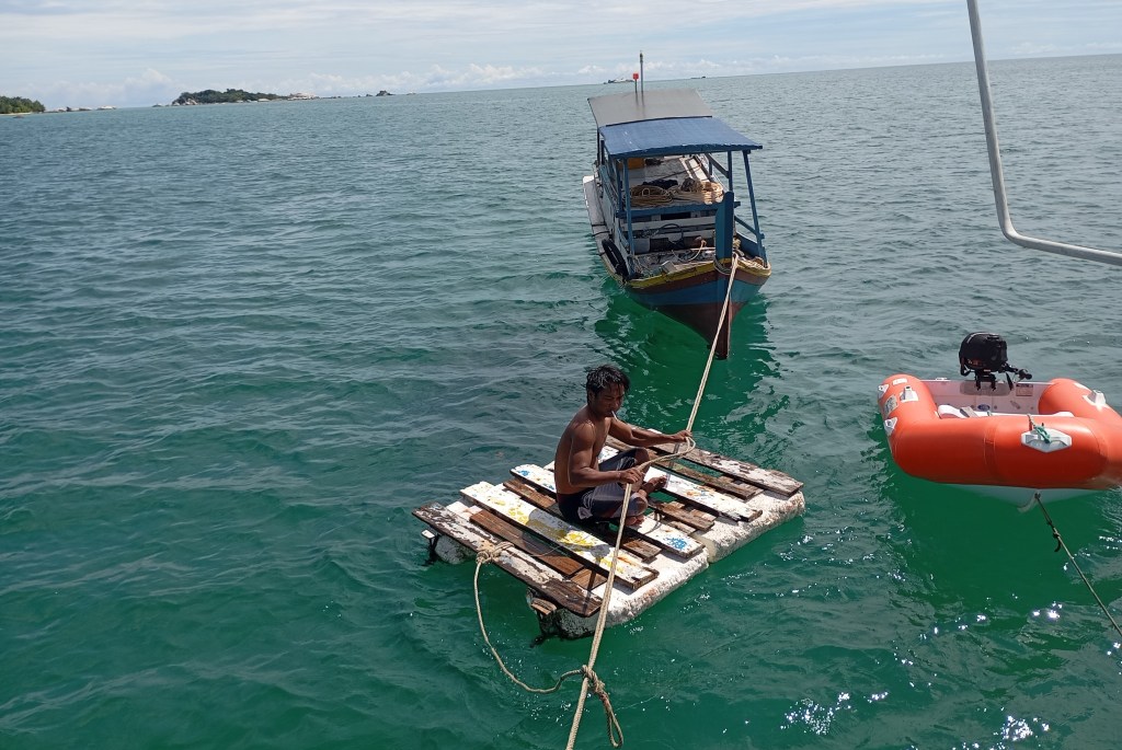 Dive support boat with divers to clean the hull. Photo Ray Penson