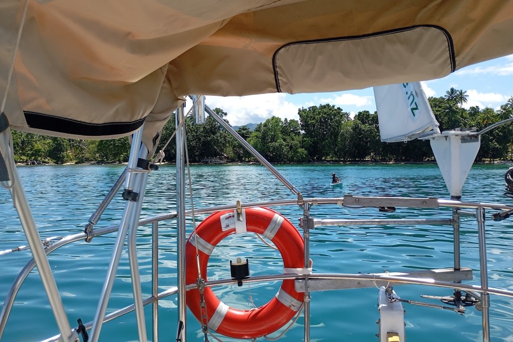Departing Conflict Bay, a last minute delivery of coconuts for the voyage by Elijah's daughter. Photo Ray Penson